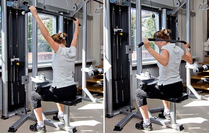 Tirer le bloc derrière votre dos sur le simulateur aide à travailler vos muscles latissimus dorsi. 